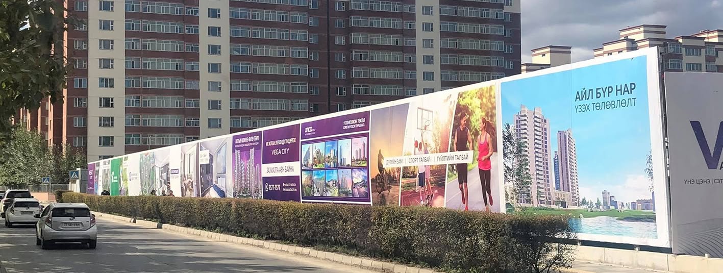 Large outdoor digital vinyl printing installed along a city construction fence